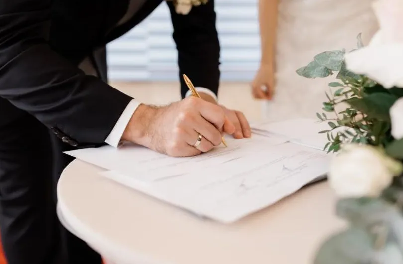 Groom signing a premarital agreement shortly before the wedding ceremony